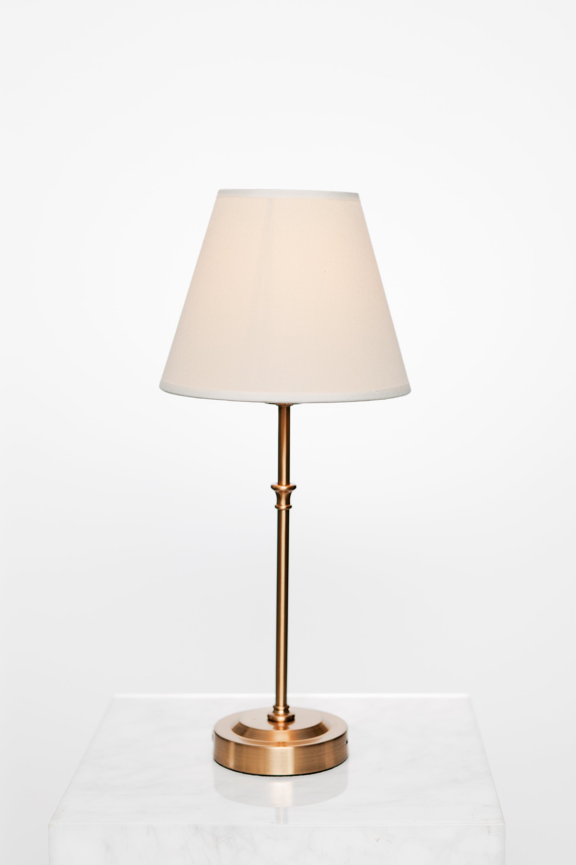 Modern styling vignette with book stack, lamp, and decorative bowl.