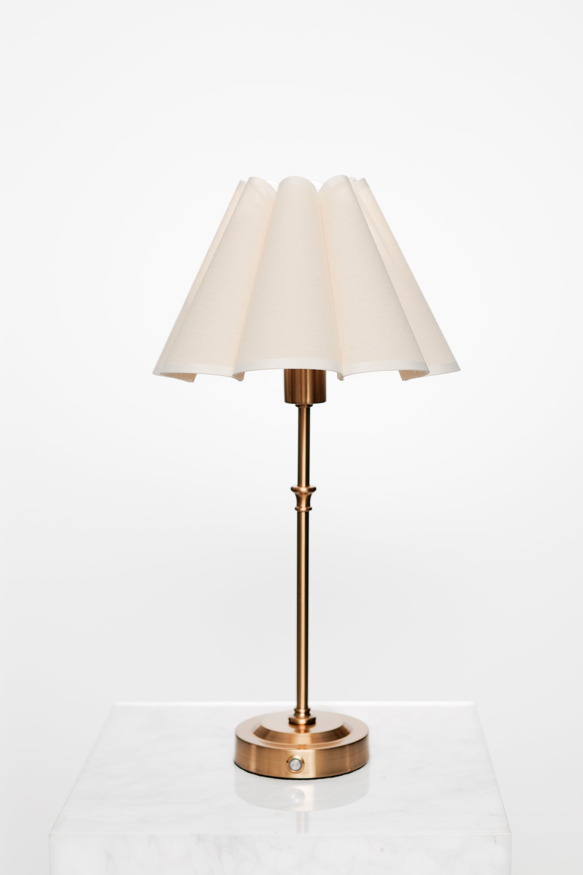 Neutral-toned living room scene with brass accent lamp on side table.