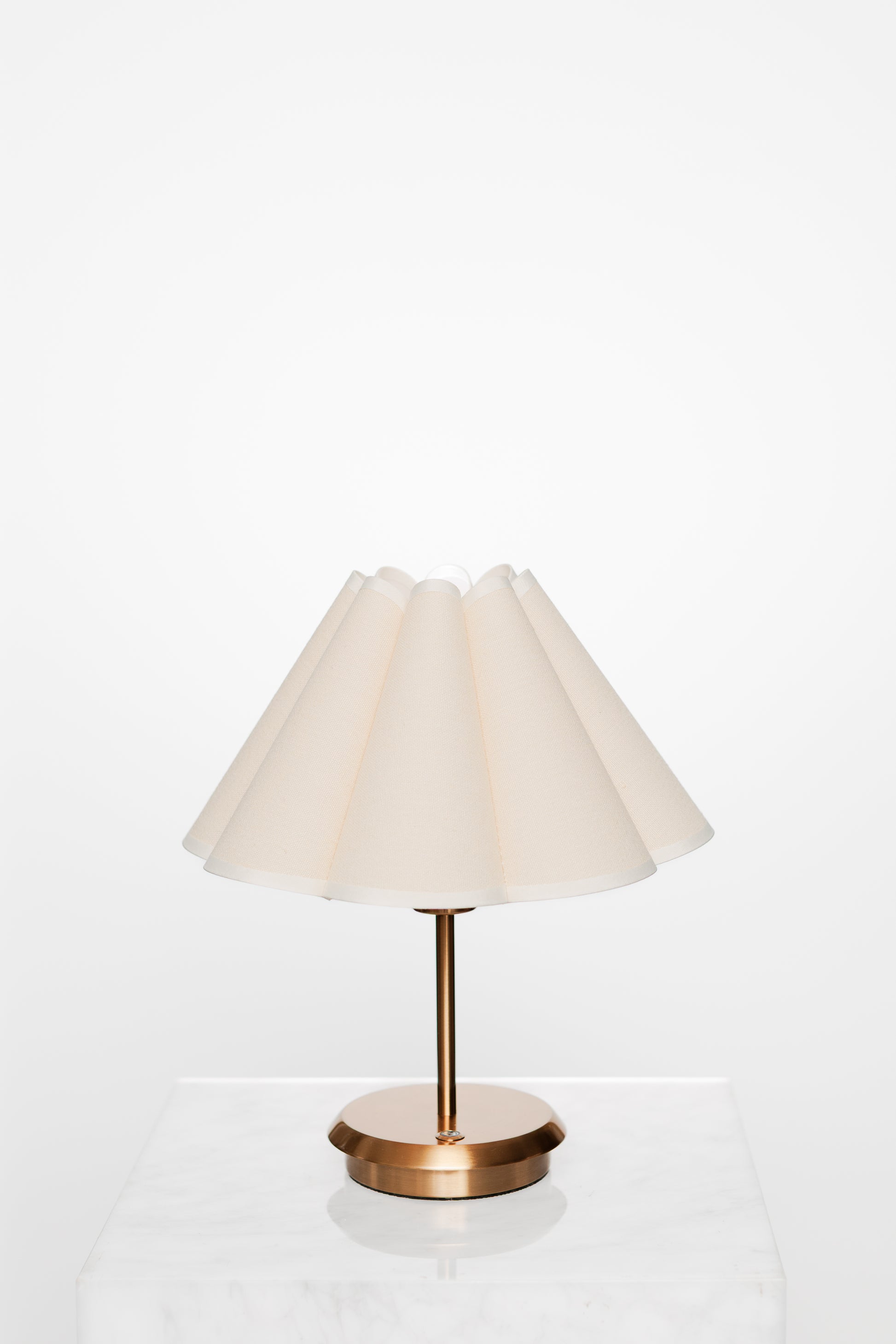 Cozy interior vignette featuring a soft sofa, brass lamp, and textured cushion.