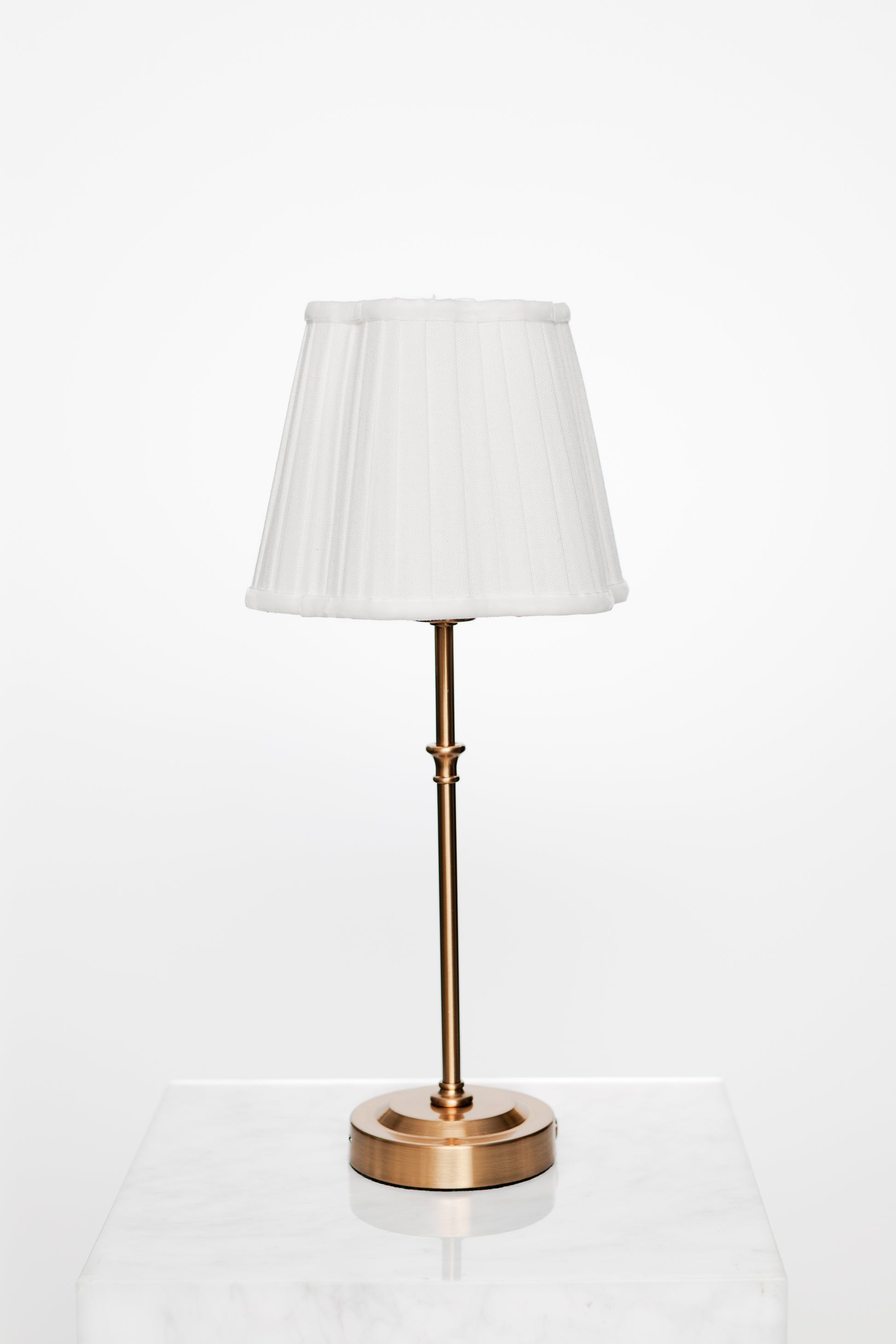 Light-filled corner with brass lamp and muted decorative accents.