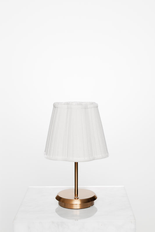 Simple corner with brass lamp, open book, and calm ambience.