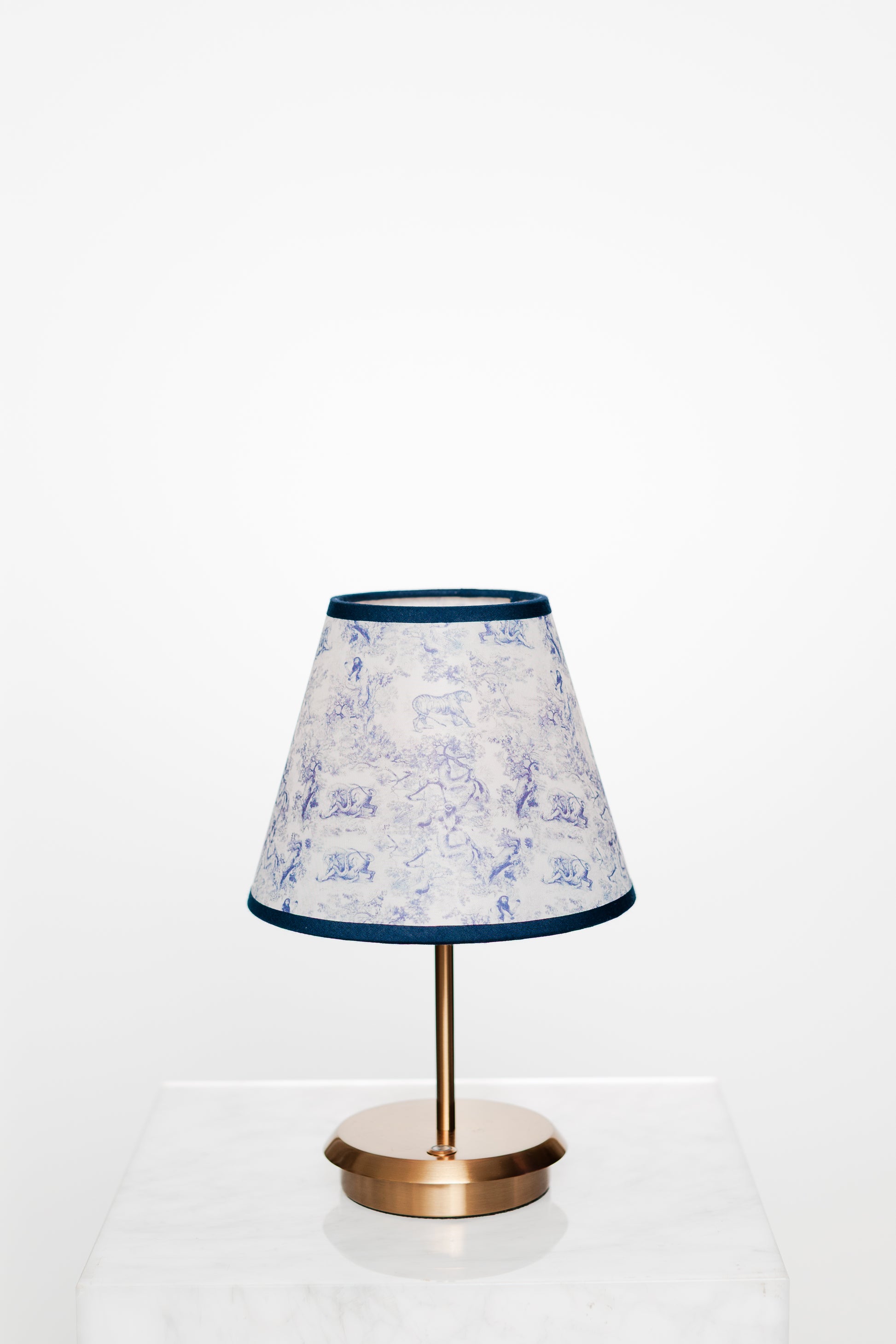 Bright corner with brass lamp and light-furnished minimal decor.