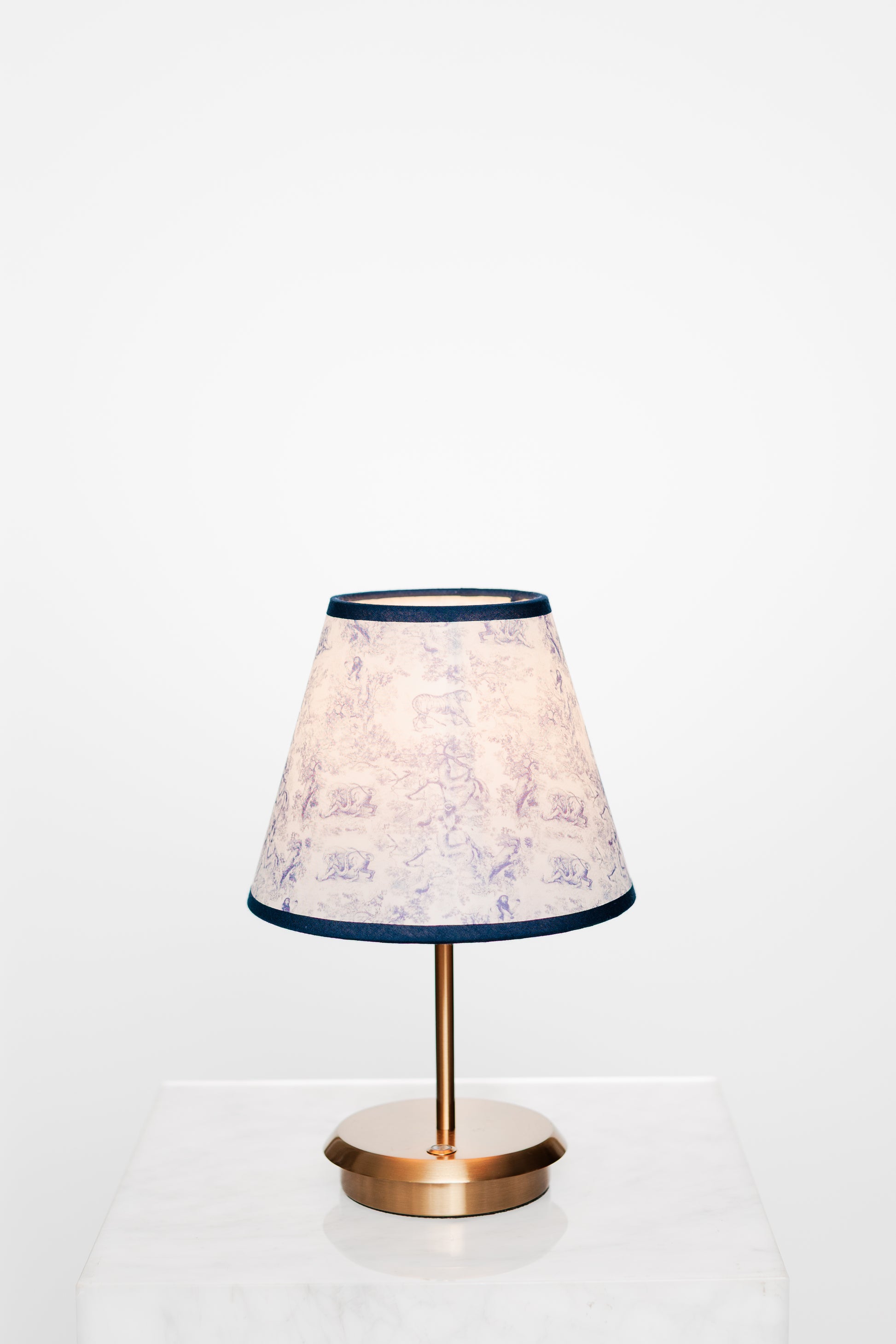 Serene bedroom corner with brass lamp, light fabrics and greenery view