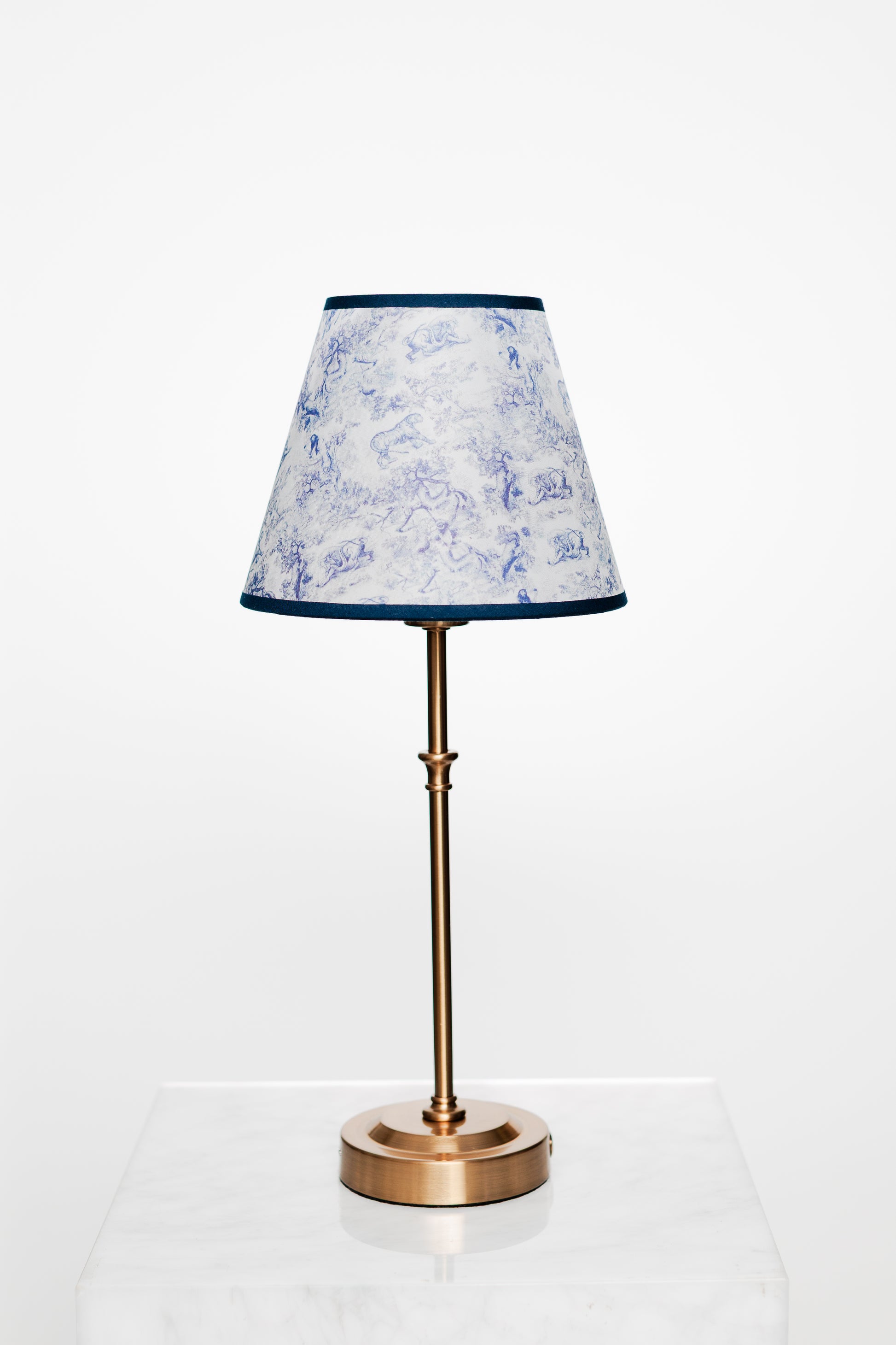 Bright linen-furnished room with brass lighting and curated tabletop styling.