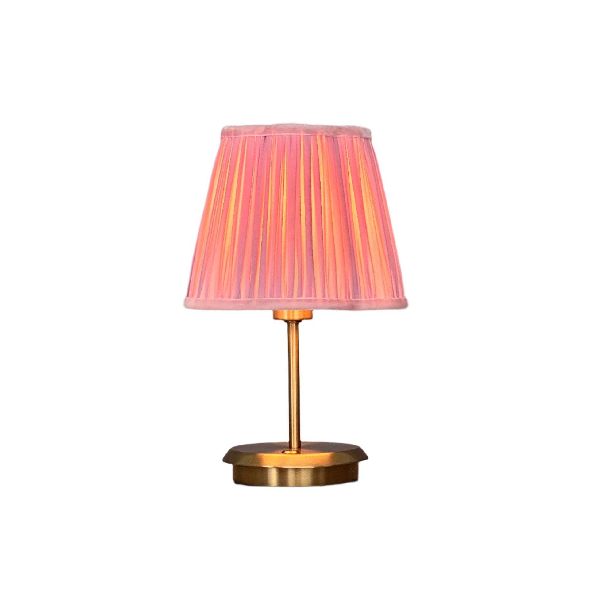 Nighttime interior with brass lamp glowing softly beside seating.