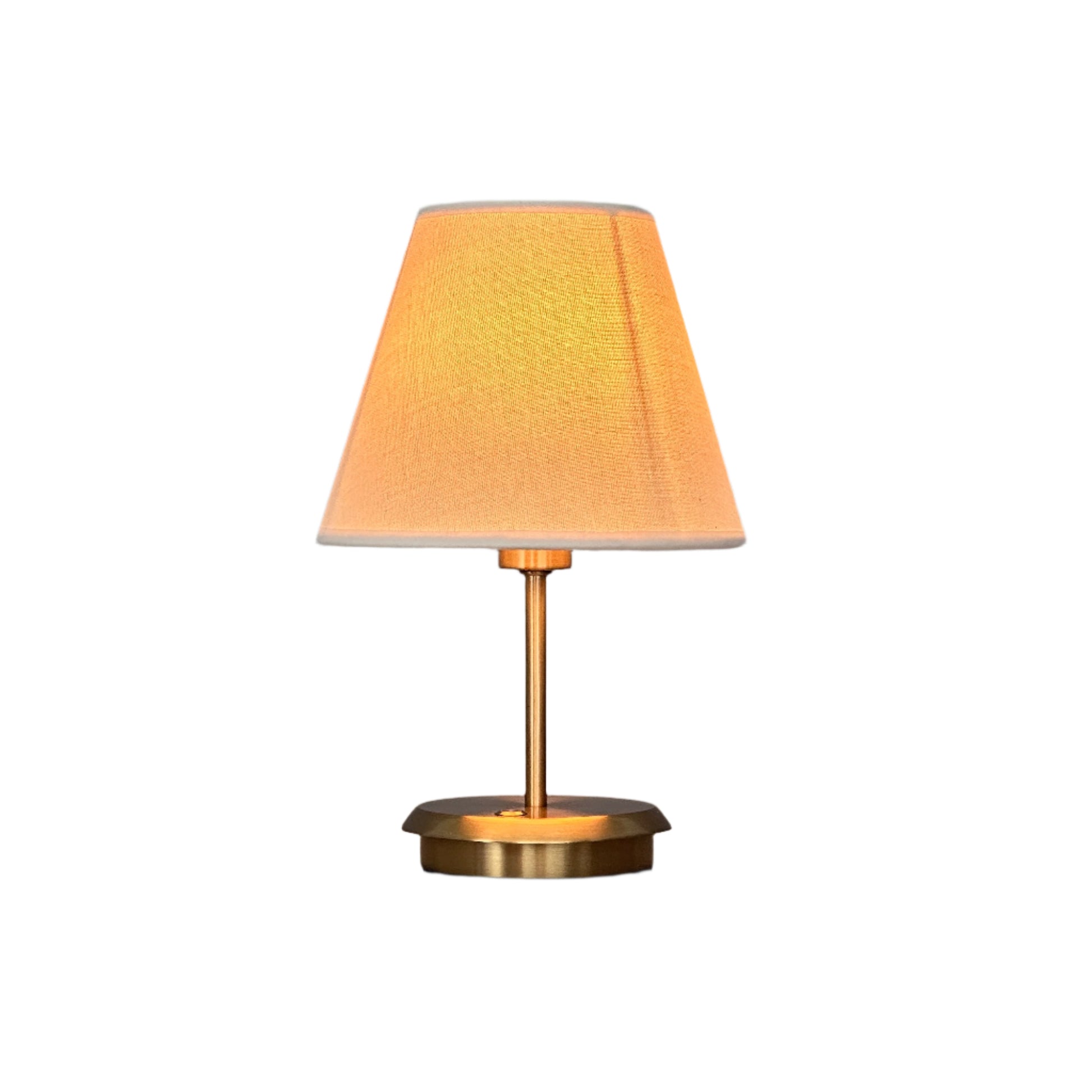 Table vignette with lamp, books and decorative object in bright space.